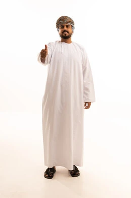 رجل عماني يرتدي الدشداشة والكمة مع إيماءة الإبهام
