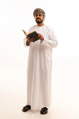 Omani Man in Traditional Dress Holding a Book