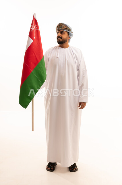 رجل عماني يحمل العلم الوطني على خلفية بيضاء