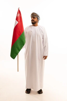 رجل عماني يحمل العلم الوطني على خلفية بيضاء