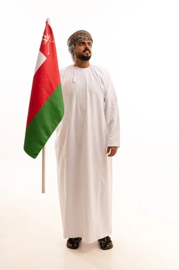 رجل عماني يحمل العلم الوطني في الاستوديو