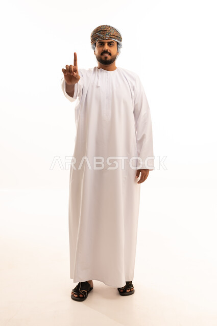 رجل عماني بالزي التقليدي يشير بإصبعه للأعلى