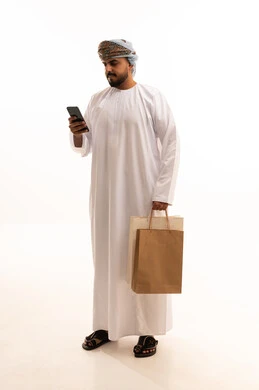 Omani Man with Shopping Bags and Smartphone in Studio