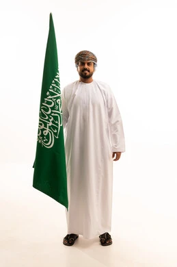 Omani Man Holding Saudi Arabian Flag on White Background