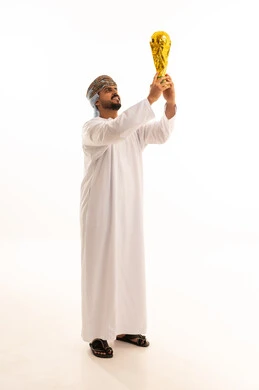رجل عماني يحمل كأس العالم الذهبي في الاستوديو