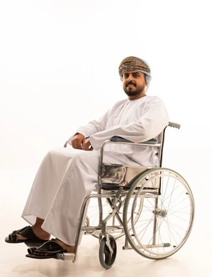 Omani Man in Wheelchair Wearing Traditional Dress