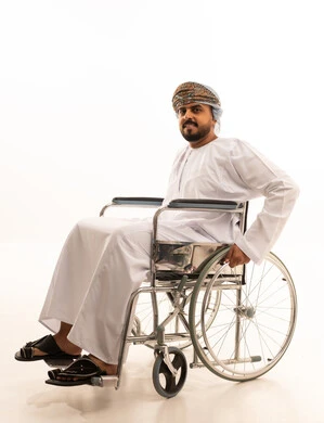 Omani Man in Wheelchair Wearing Traditional Dress