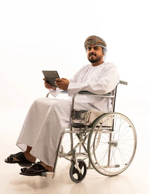 Omani Disabled Man in Wheelchair Using Digital Tablet