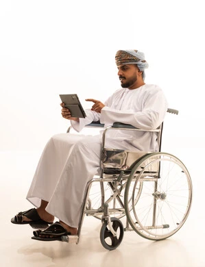 Omani Man in Wheelchair Using Digital Tablet