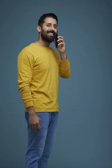 Saudi Man Talking on Smartphone in Casual Yellow Shirt