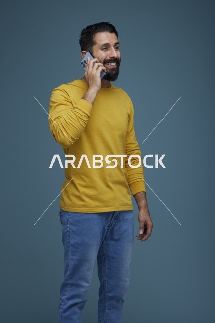 شاب سعودي يتحدث بالهاتف بملابس كاجوال صفراء