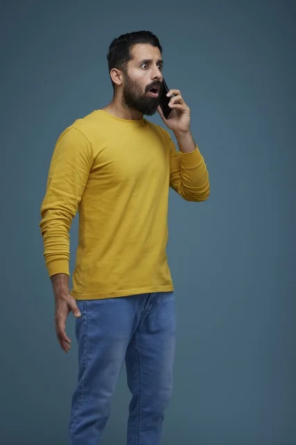 Shocked Saudi Man Talking on Smartphone in Studio Setting