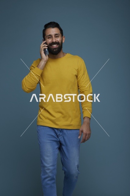 شاب سعودي يتحدث بالهاتف الذكي بملابس كاجوال