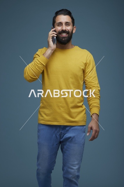 شاب سعودي يتحدث بالهاتف الذكي بملابس كاجوال