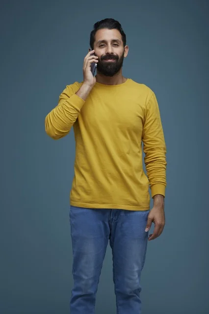 شاب سعودي يتحدث بالهاتف الذكي بملابس كاجوال
