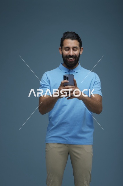 شاب سعودي يستخدم الهاتف الذكي بخلفية زرقاء