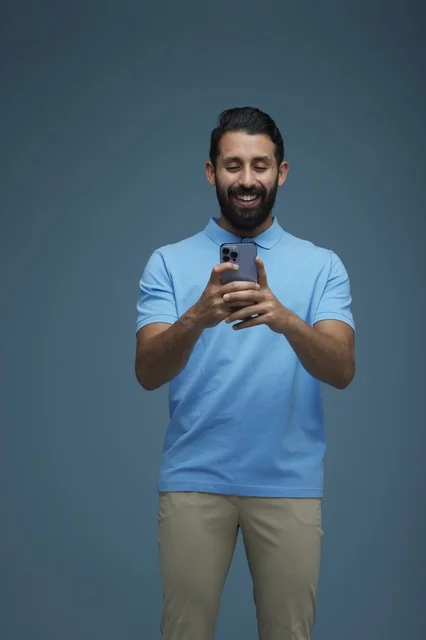 شاب سعودي يستخدم الهاتف الذكي بملابس كاجوال