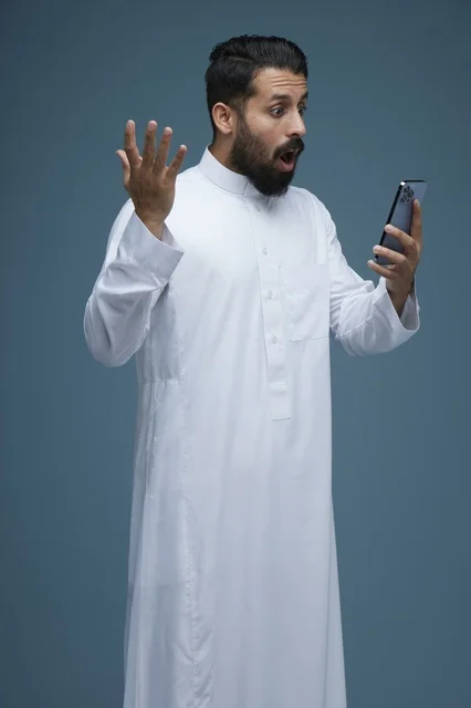 رجل سعودي بالثوب التقليدي مصدوم من الهاتف