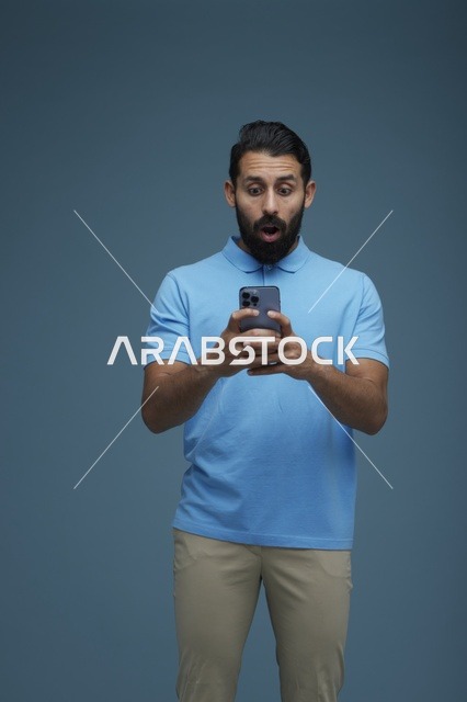 شاب سعودي متفاجئ يستخدم الهاتف الذكي بملابس كاجوال