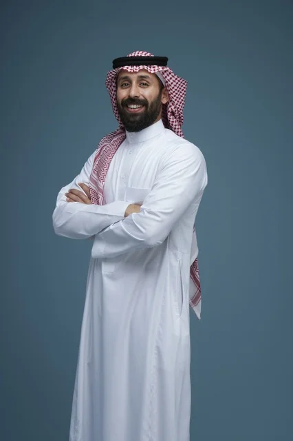 رجل سعودي يرتدي الزي التقليدي يبتسم في الاستوديو