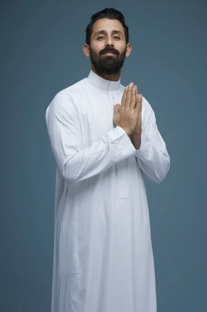 رجل سعودي بالثوب الأبيض يقوم بإيماءة الترحيب