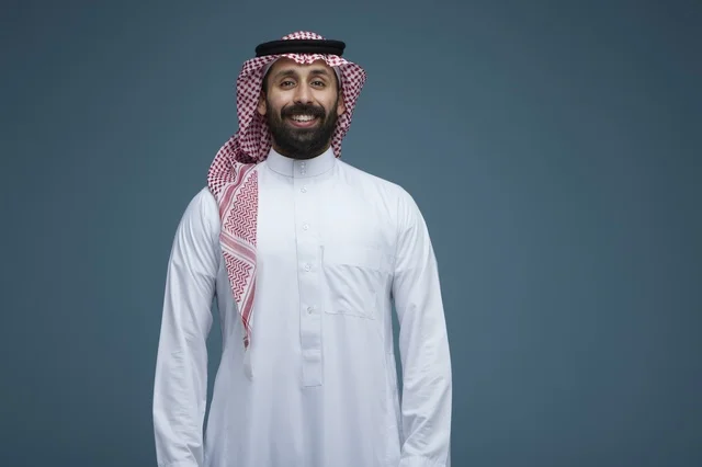 رجل سعودي مبتسم يرتدي الثوب التقليدي والشماغ