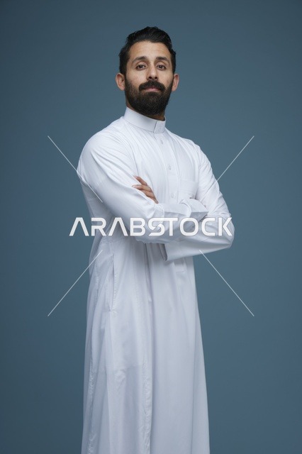 رجل سعودي بالثوب الأبيض في استوديو بخلفية زرقاء