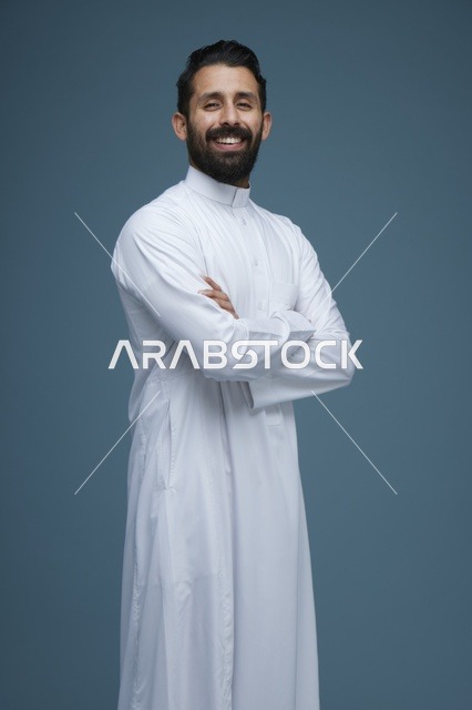 رجل سعودي يبتسم بالثوب الأبيض على خلفية زرقاء