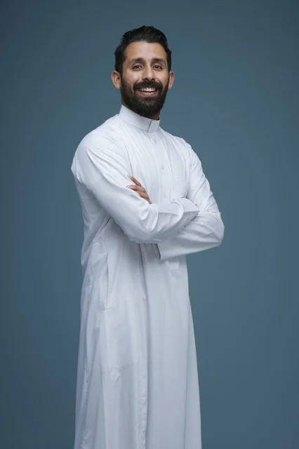 رجل سعودي مبتسم بالثوب الأبيض التقليدي