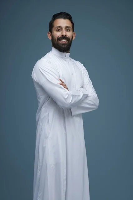 Saudi Man in Traditional White Thobe Smiling in Studio Portrait