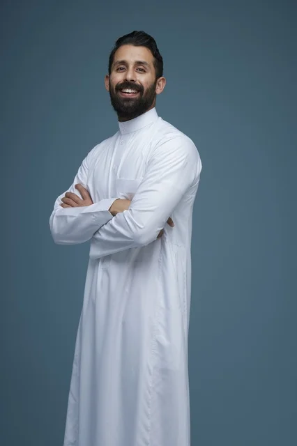 رجل سعودي يرتدي الثوب الأبيض التقليدي بابتسامة واثقة