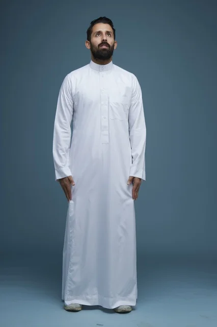 رجل سعودي بالثوب الأبيض ينظر للأعلى لقطة استوديو كاملة