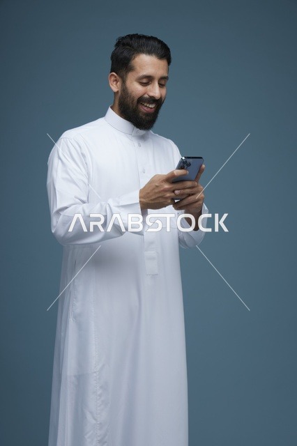 رجل سعودي يستخدم الهاتف الذكي بالثوب التقليدي