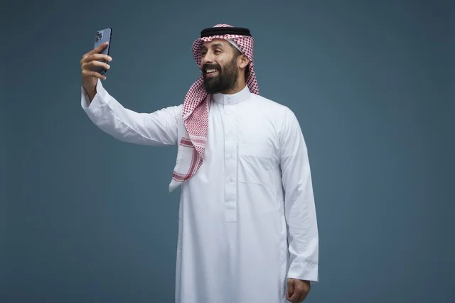 رجل سعودي يلتقط صورة سيلفي بالهاتف الذكي بالثوب