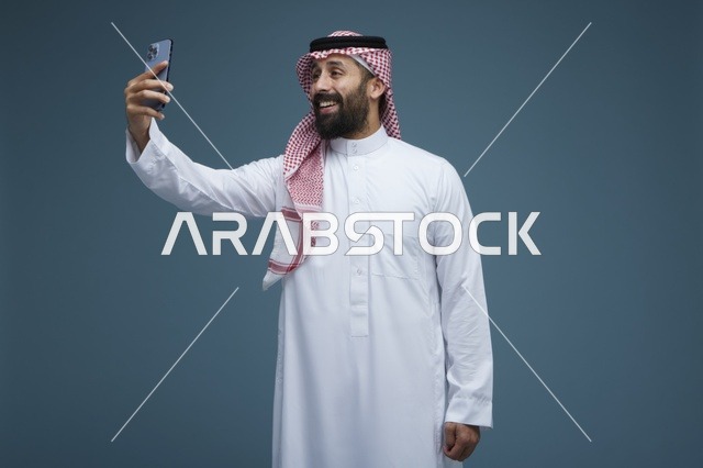 رجل سعودي يلتقط صورة سيلفي بالهاتف الذكي