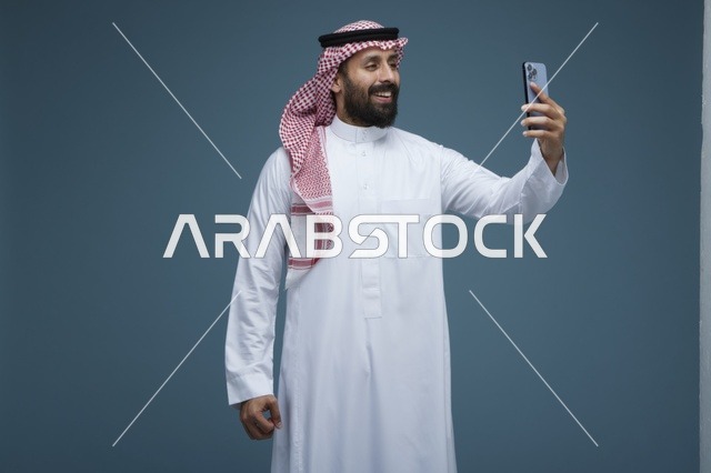 رجل سعودي يلتقط سيلفي بالهاتف الذكي في استوديو