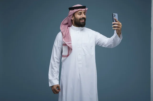 رجل سعودي يلتقط سيلفي بالهاتف الذكي في استوديو