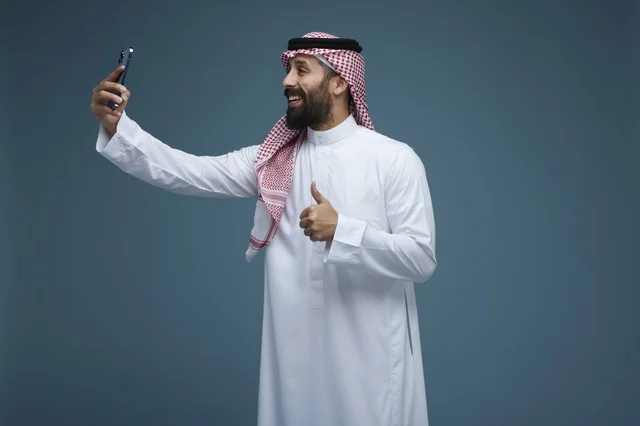Saudi Man Taking Smartphone Selfie with Thumbs Up