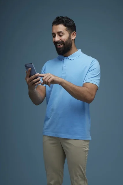 Saudi Man Using Smartphone in Casual Studio Portrait