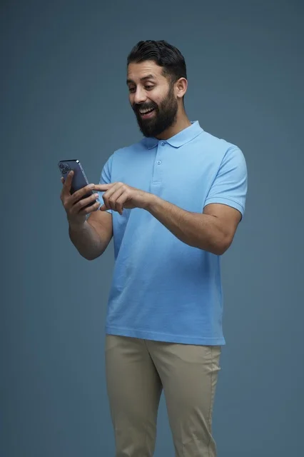 Saudi Man Using Smartphone in Casual Attire