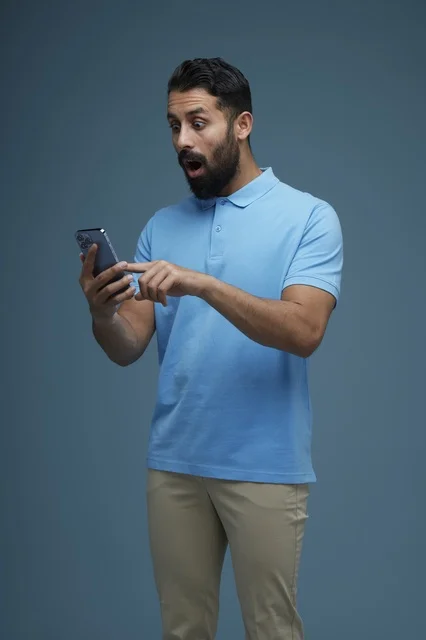 Shocked Saudi Man Using Smartphone in Casual Clothes
