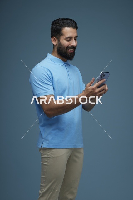 رجل سعودي يستخدم الهاتف الذكي بخلفية زرقاء