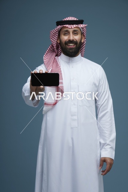 رجل سعودي يحمل هاتف ذكي بشاشة فارغة