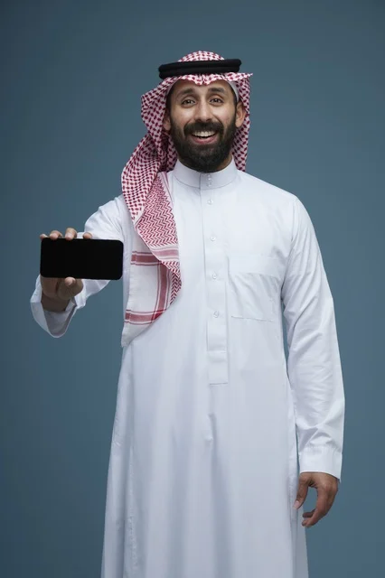 رجل سعودي يحمل هاتف ذكي بخلفية زرقاء