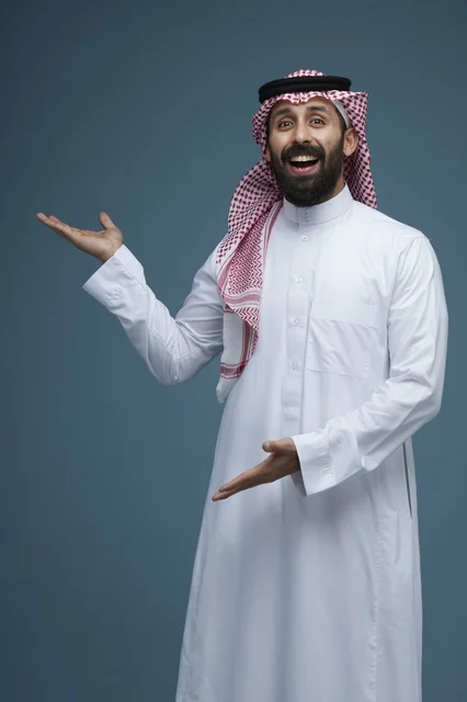 رجل سعودي بالزي التقليدي يشير بيديه في استوديو