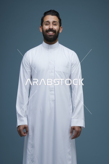 رجل سعودي مبتسم بالثوب الأبيض في الاستوديو