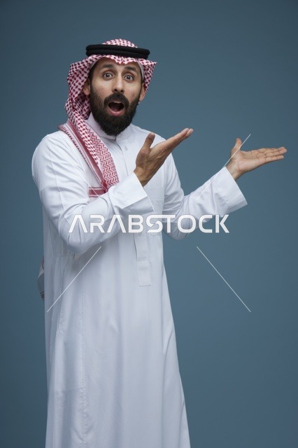 رجل سعودي مصدوم يشير بيده بالزي التقليدي في استوديو