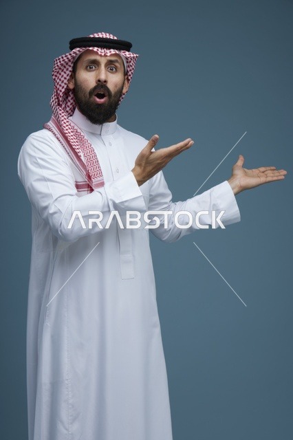 Surprised Saudi Man Gesturing on Blue Studio Background
