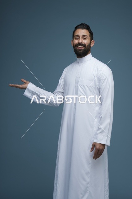 رجل سعودي بالثوب الأبيض يشير بيده في الاستوديو