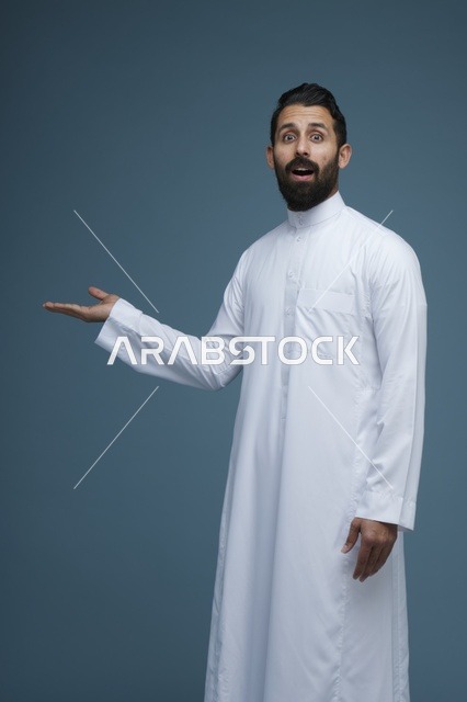 رجل سعودي مندهش يرتدي الثوب ويشير بيده